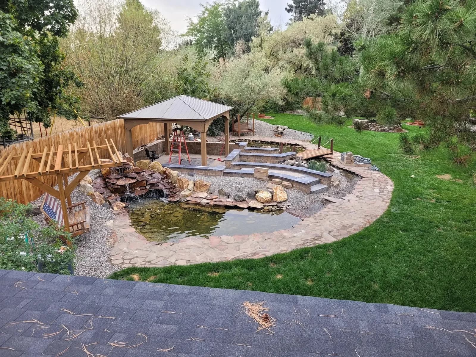 backyard water feature pond waterfall gazebo stone retaining walls and flagstone walkway landscaping