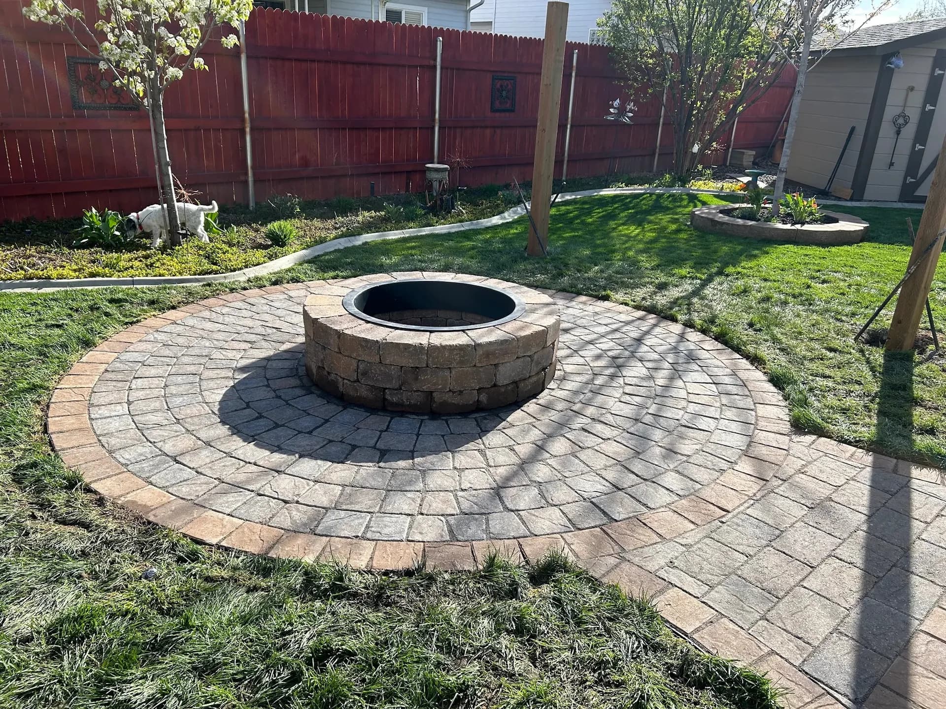 circular paver patio stone fire pit walkway and garden bed landscaping