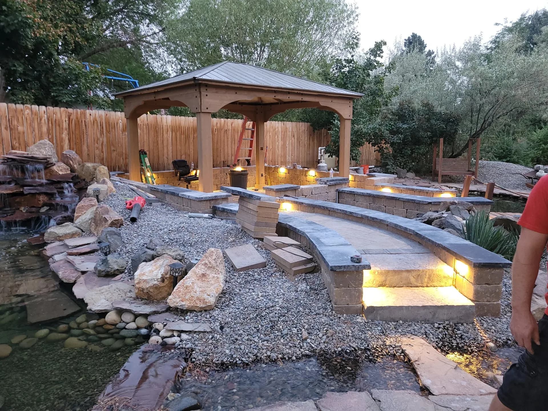 custom gazebo water feature waterfall with landscape lighting and stone retaining walls