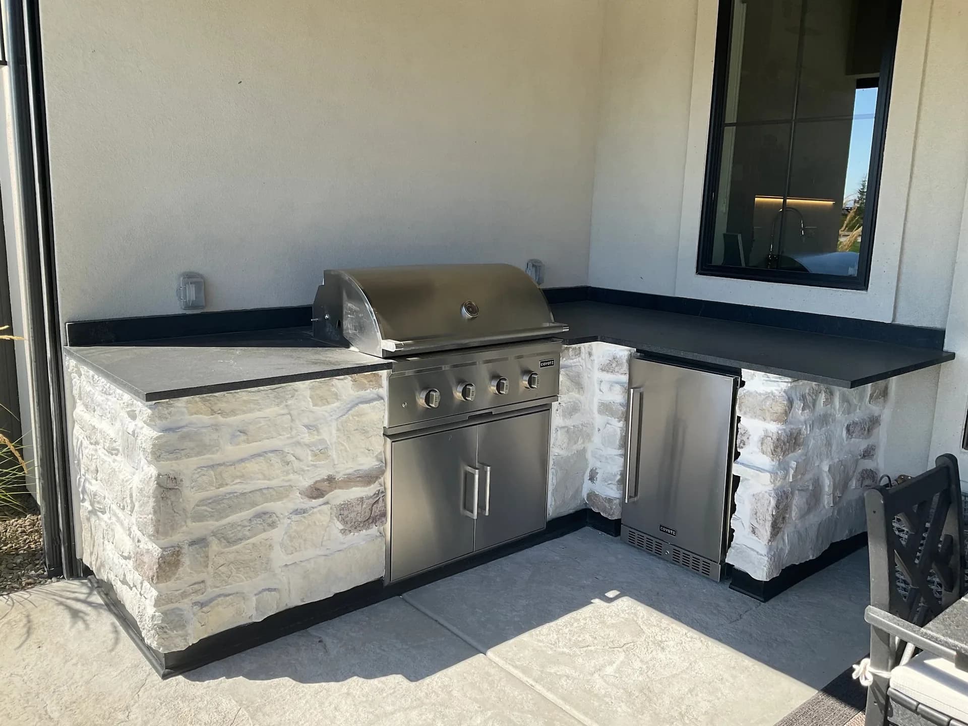custom outdoor kitchen coyote grill stone veneer concrete patio