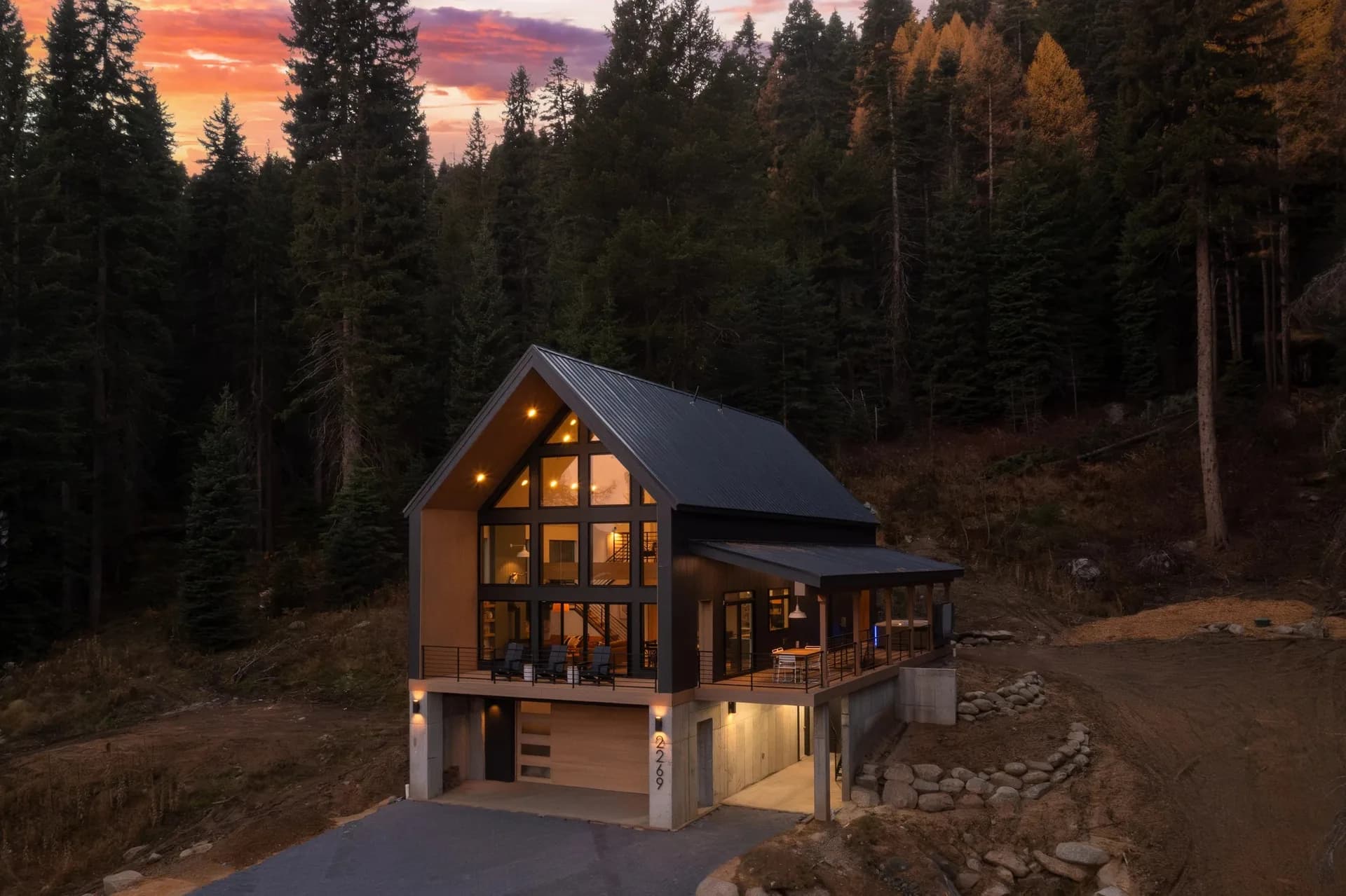 mountain modern home boulder retaining walls and landscape grading at dusk